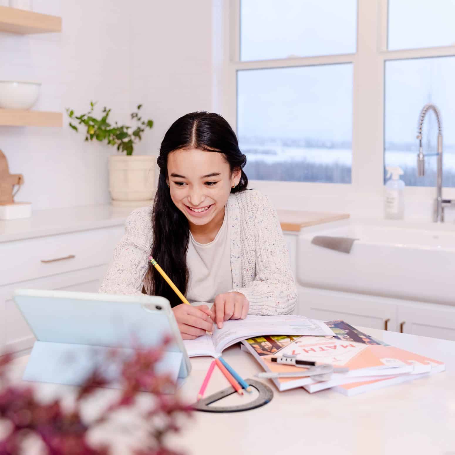 Photograph of Girl Working on Math Curriculum for Grade 7 whilst Watching Lesson on Tablet